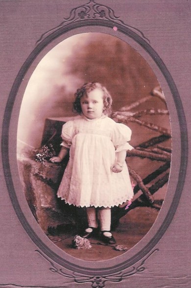 A young child in a white dressDescription automatically generated